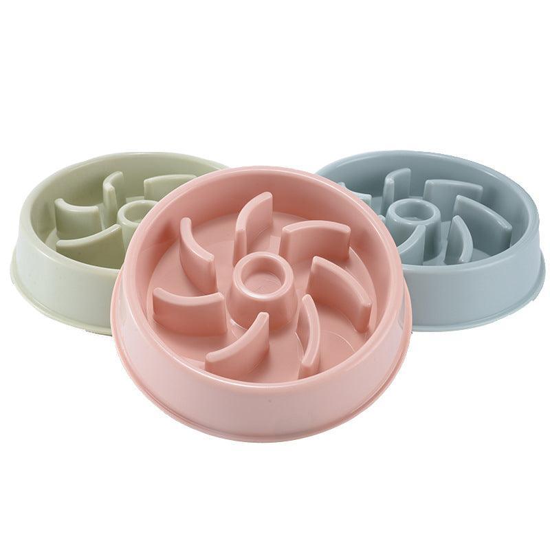 Three pet bowls with textured bottoms in pink, green, and blue on a white background