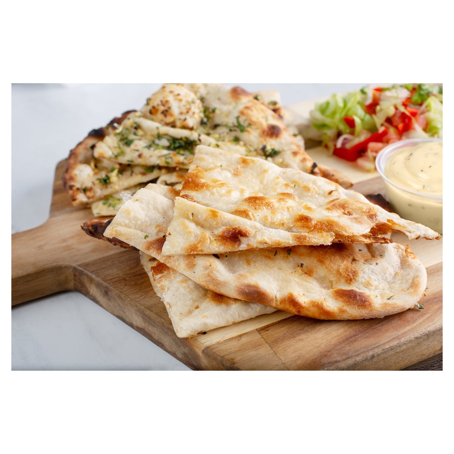 Stack of flatbreads on a wooden board with a blurred background